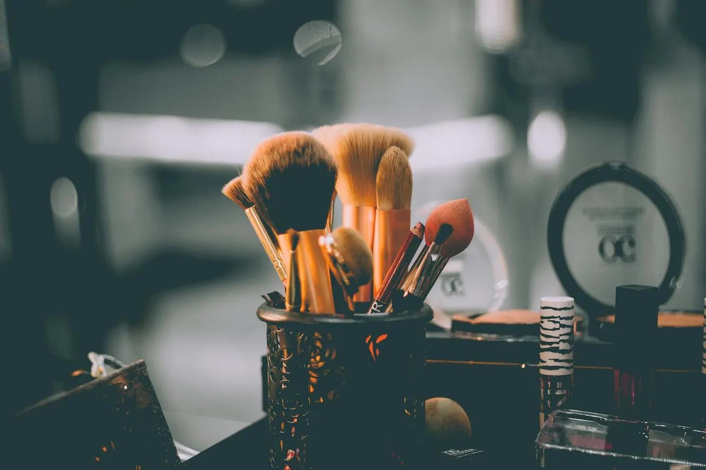 Makeup brushes in a holder at a salon workstation