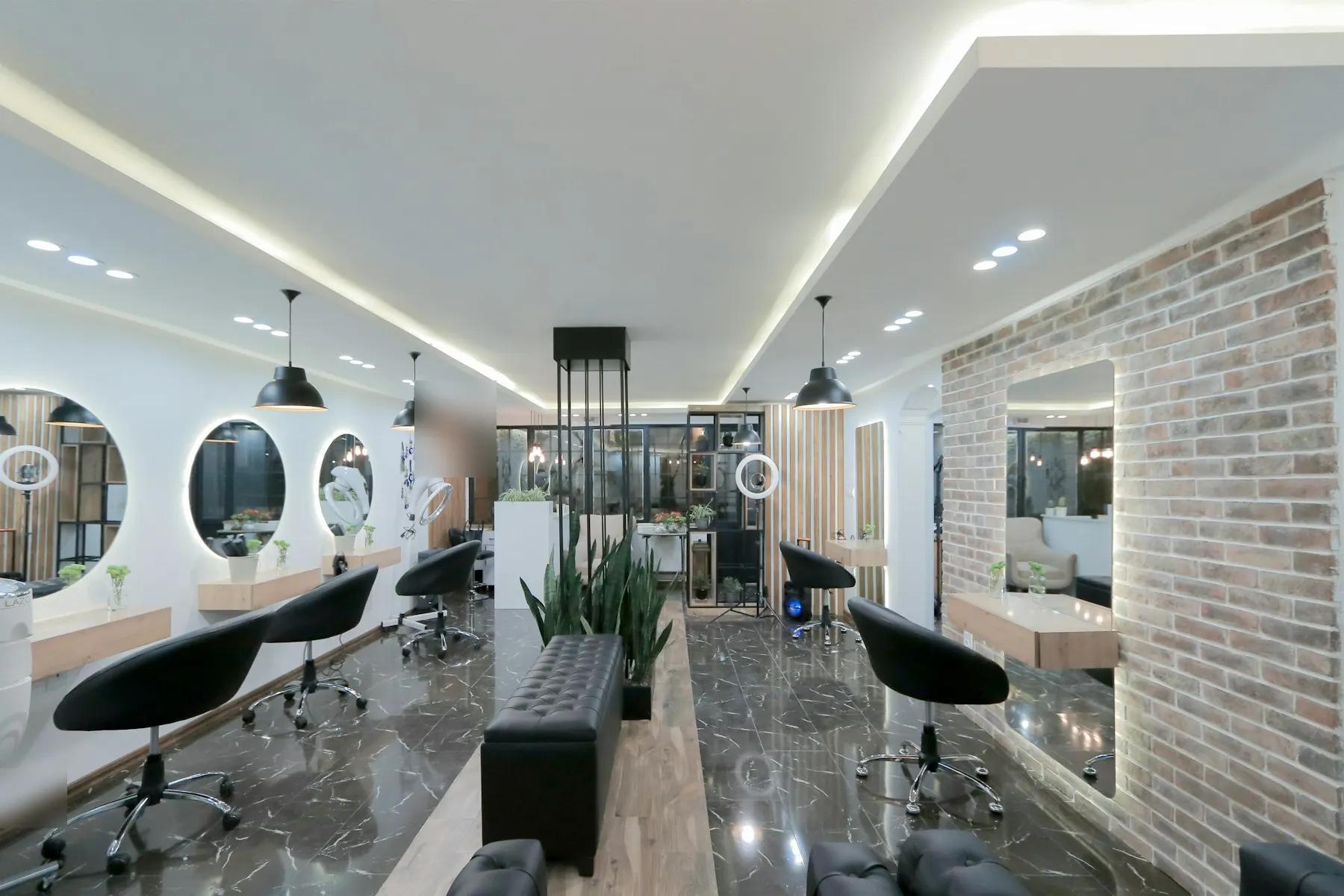 Modern beauty salon interior with styling chairs and lit mirrors